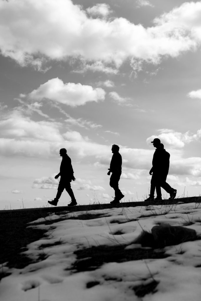 Three men walking on a mountain in Boulder Colorado